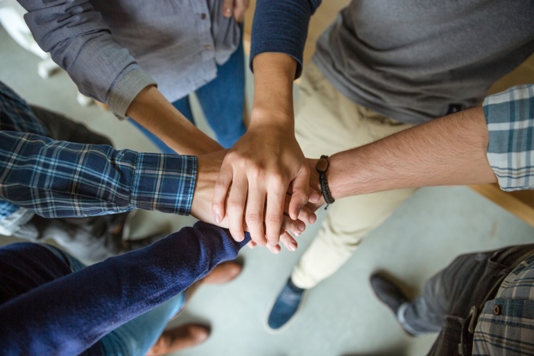 Top view of people joining hands together as a symbol of partnership.jpeg